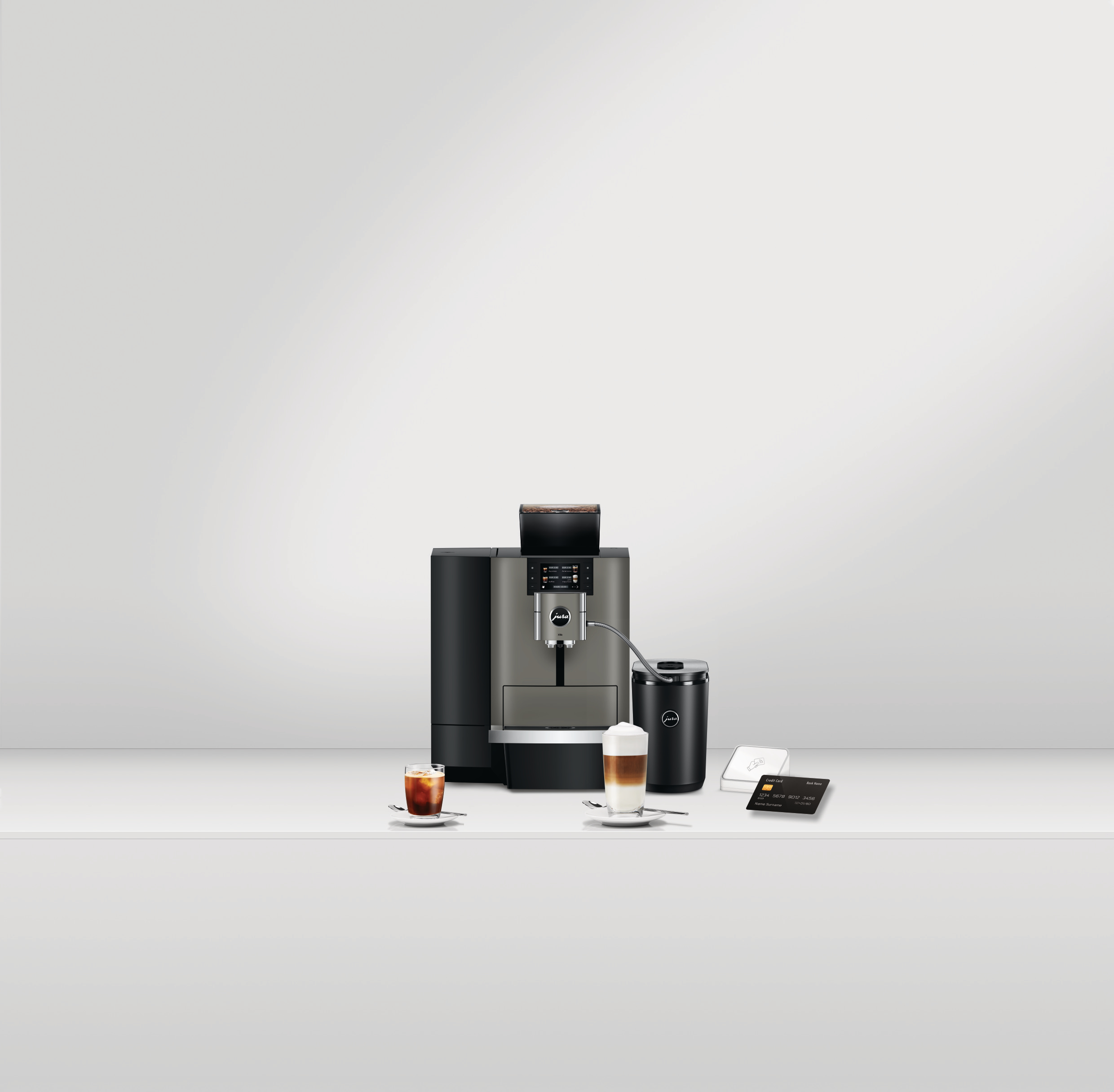 Kaffeemaschine mit Kaffee, Latte und Zubehör. Kreditkarte und Zahlungsgerät sind rechts.