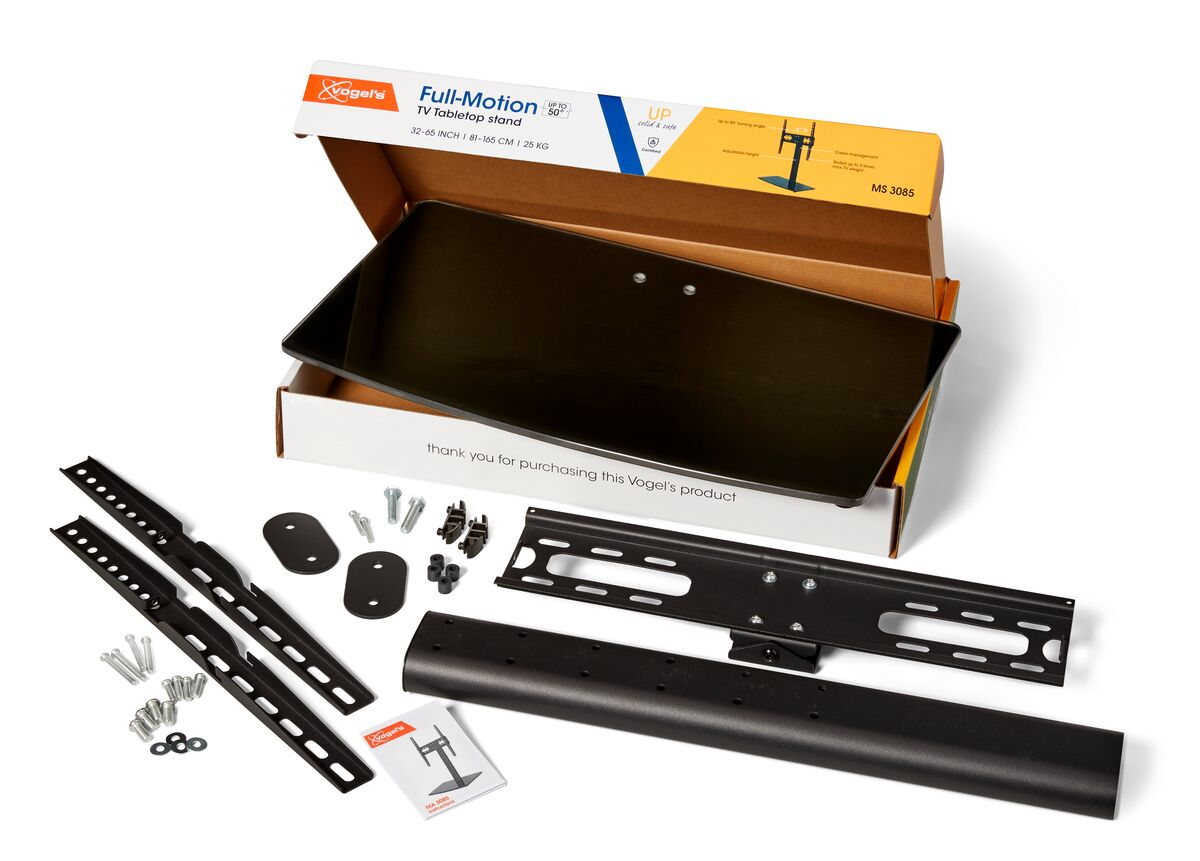 TV-Tabletop-Ständer-Kit. Enthält eine Box, Ständerteile, Montagematerial und Anweisungen. Schwarze und silberne Komponenten auf weißem Untergrund.