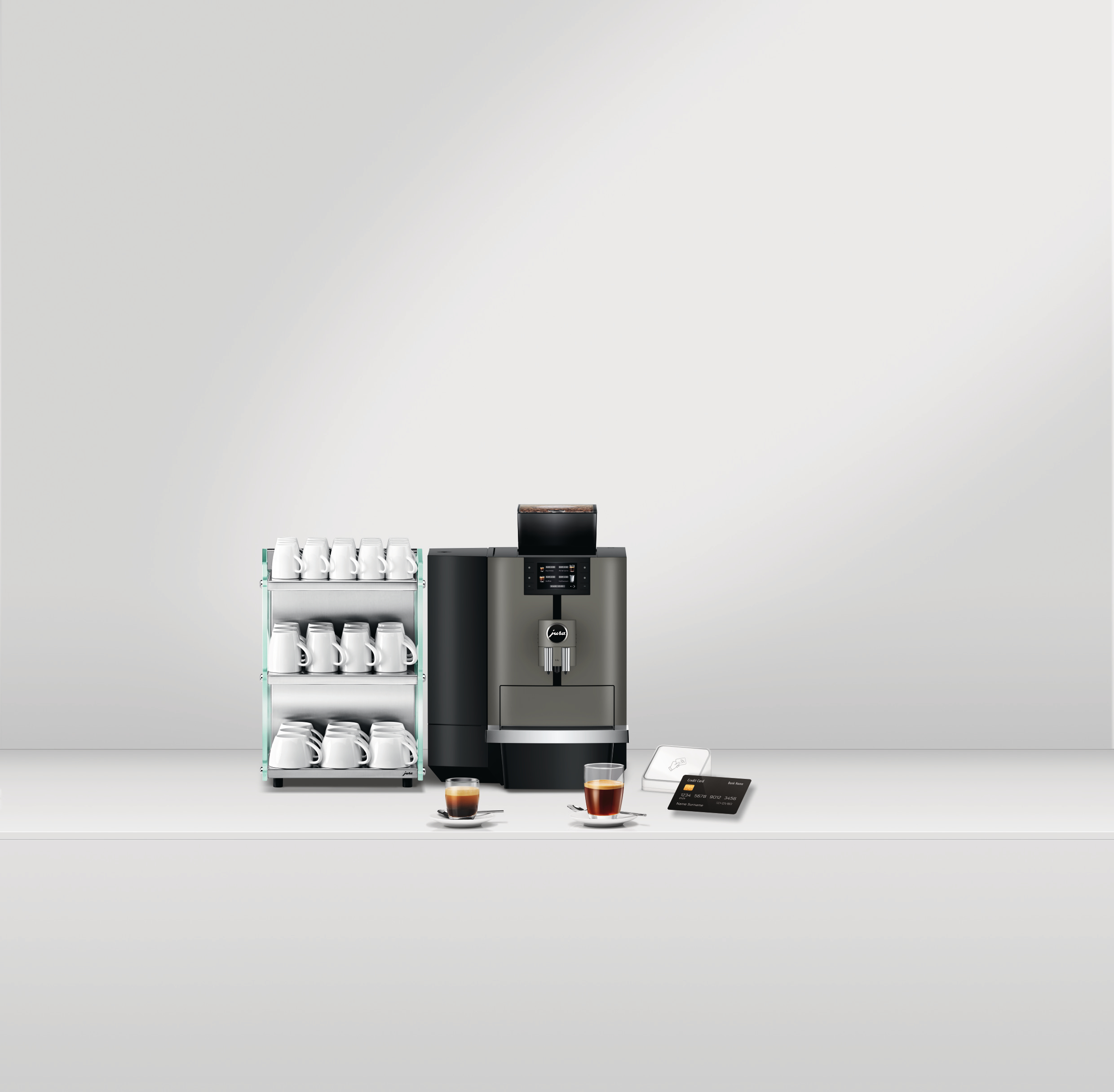 Kaffeemaschine, Tassen, Espresso, Kartenleser und Kreditkarte auf weißer Oberfläche, vor weißem Hintergrund.