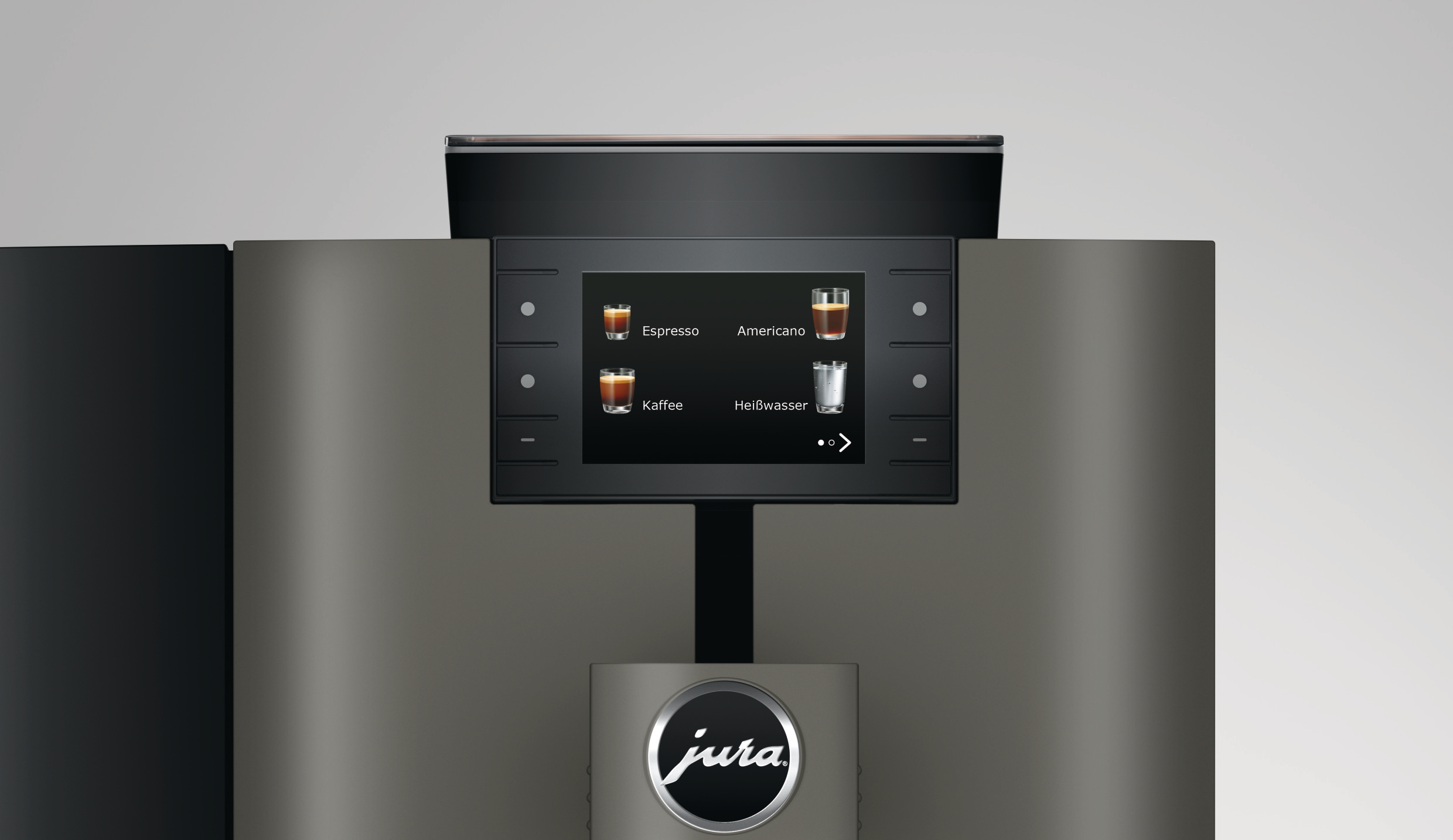 Eine Kaffeemaschine mit Bildschirm, der Kaffeeoptionen anzeigt: Espresso, Americano, Kaffee und Heißwasser. Das Jura-Logo ist sichtbar.
