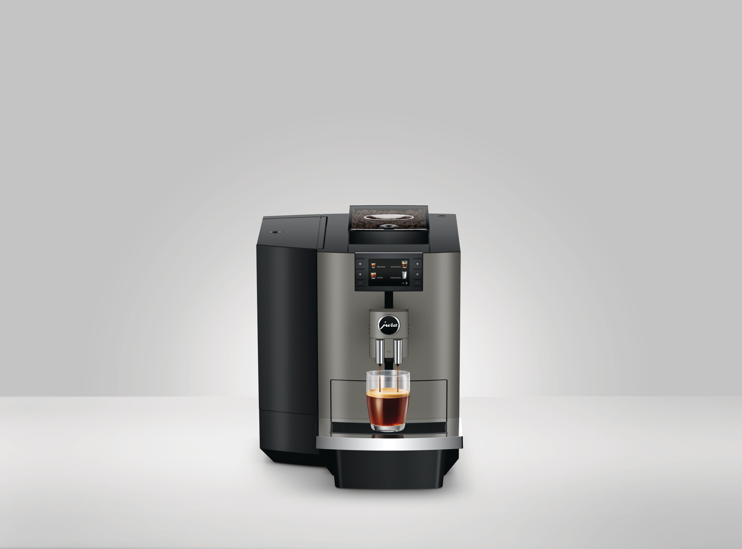 Eine Kaffeemaschine mit einem Glas Kaffee. Die Maschine ist grau und schwarz, auf weißem Untergrund mit grauem Hintergrund.