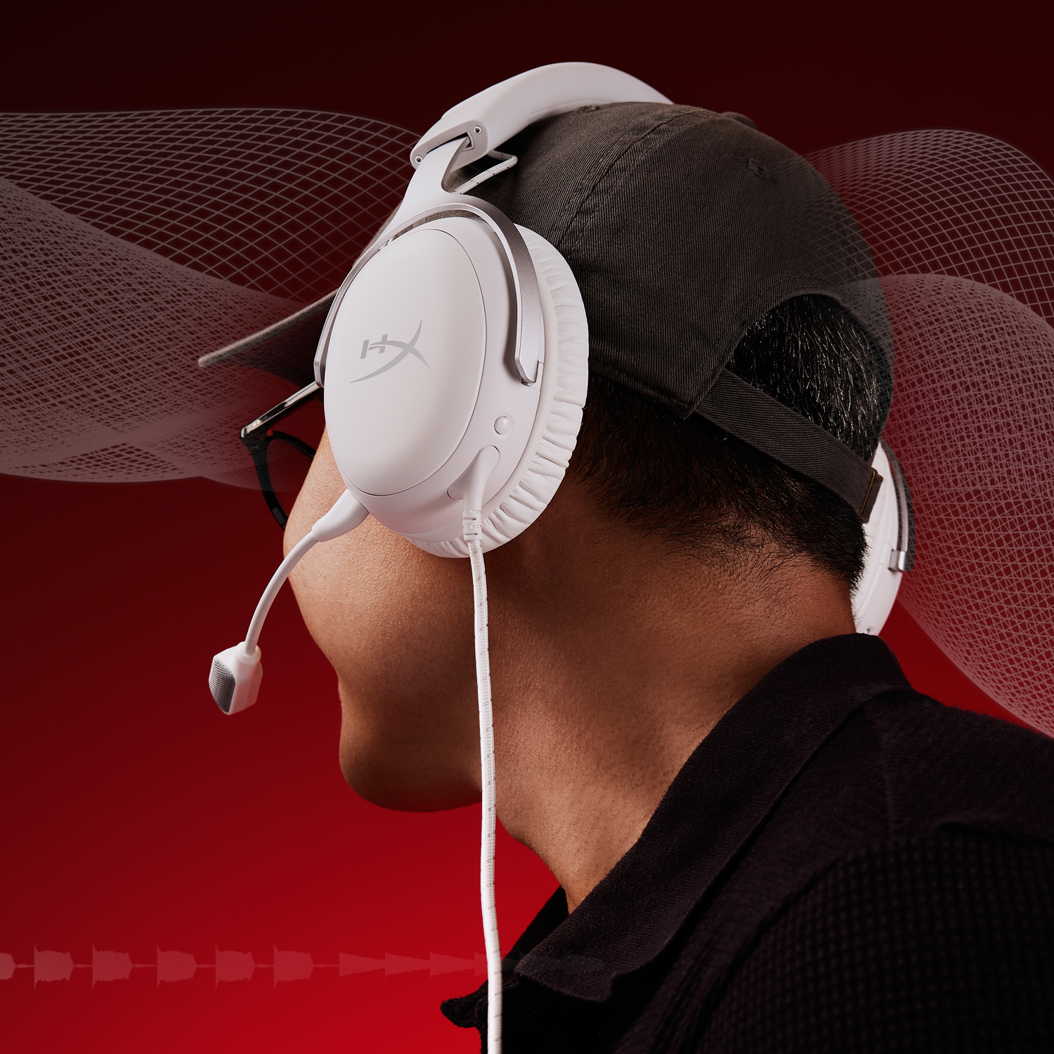 Een persoon draagt een witte headset, een zwarte pet en een zwart shirt. Rode achtergrond met wit golfpatroon.