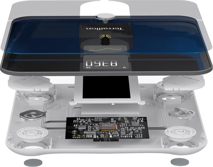 Vista esplosa di una bilancia digitale. Il display mostra 83,6 kg. Sono visibili componenti interni come un circuito stampato.