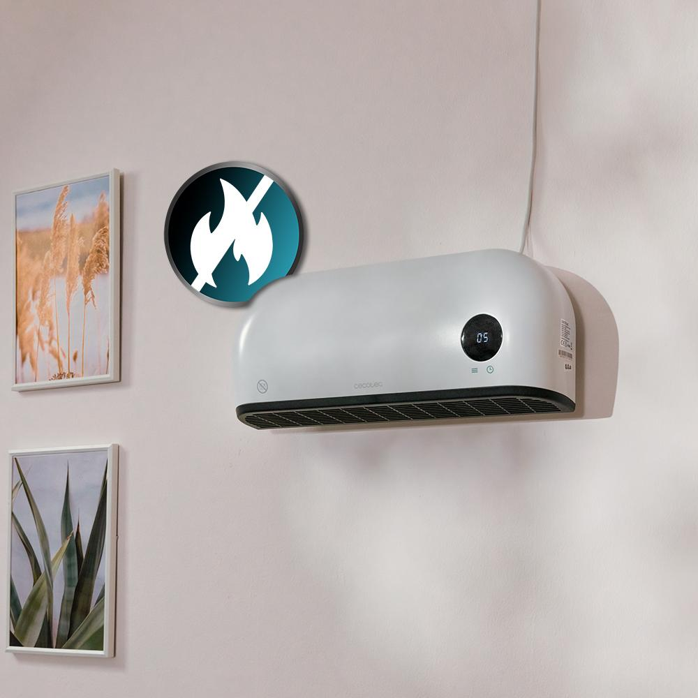 Un calentador blanco montado en la pared con una pantalla digital. Un símbolo de no fuego está encima. Dos cuadros enmarcados cuelgan debajo.