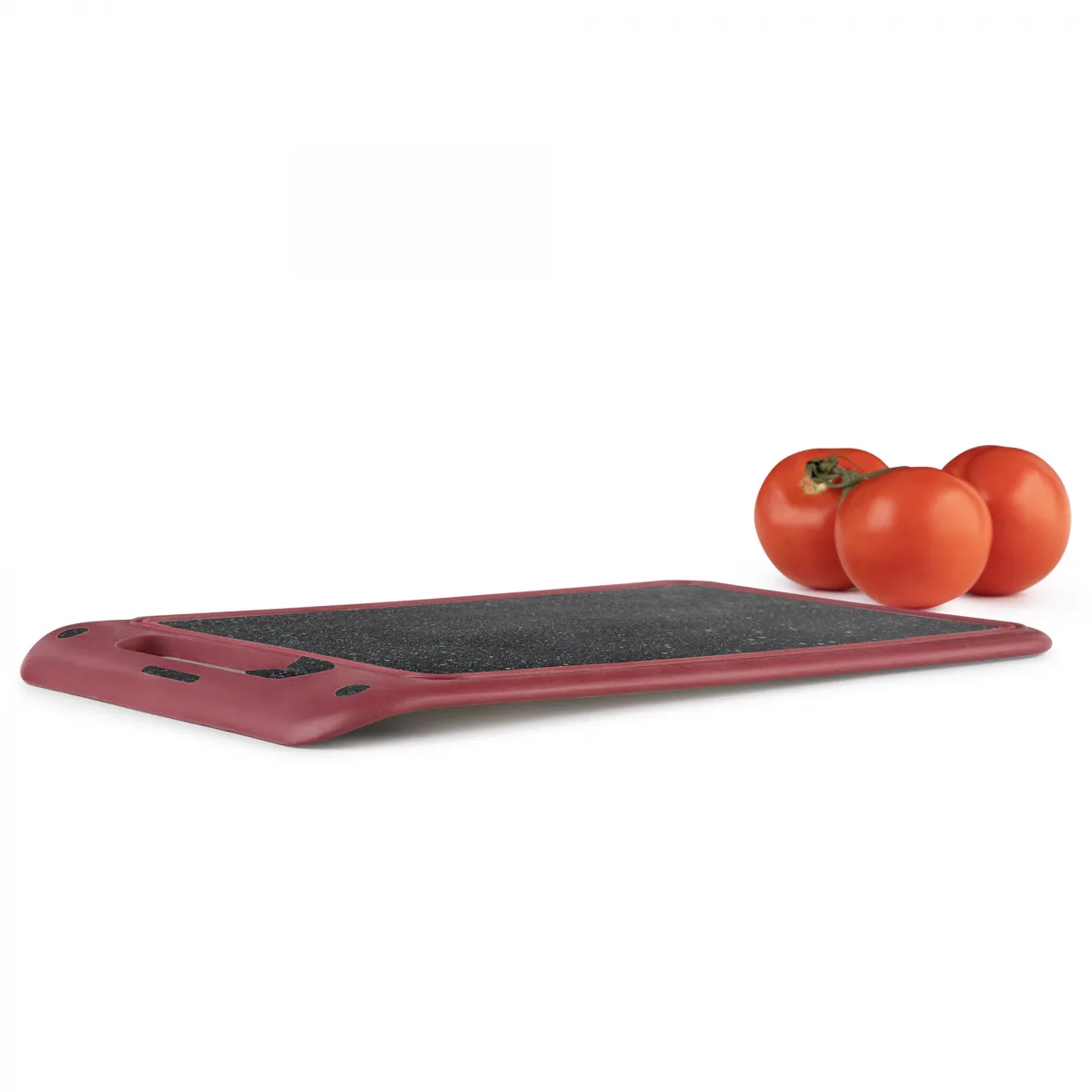 Una tabla de cortar roja con tres tomates. La tabla tiene una superficie negra y un borde rojo.