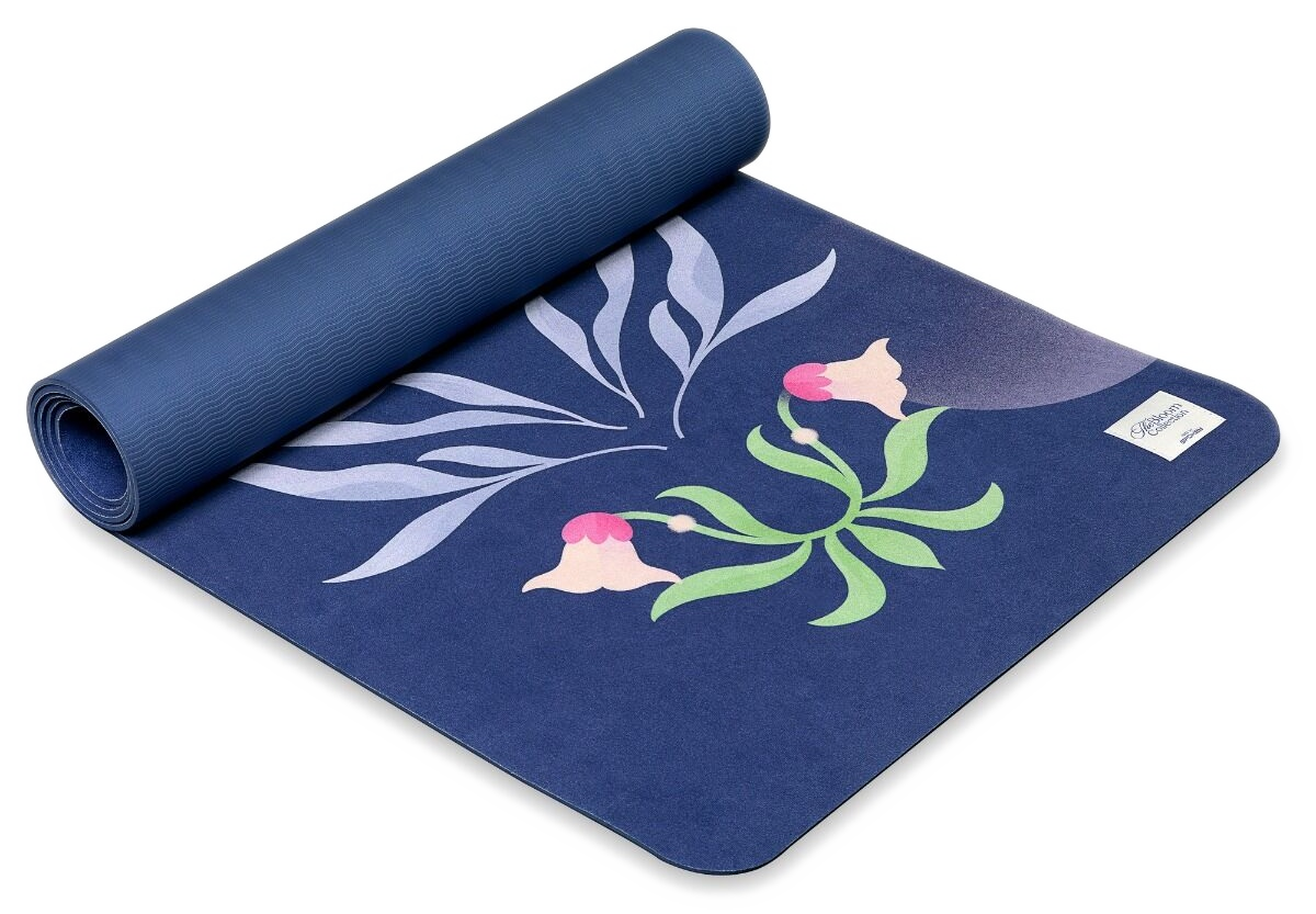 Zwinięta mata do jogi, niebieska z kwiatowym wzorem. Różowe kwiaty i zielone łodygi na ciemnoniebieskim tle z białymi liśćmi.