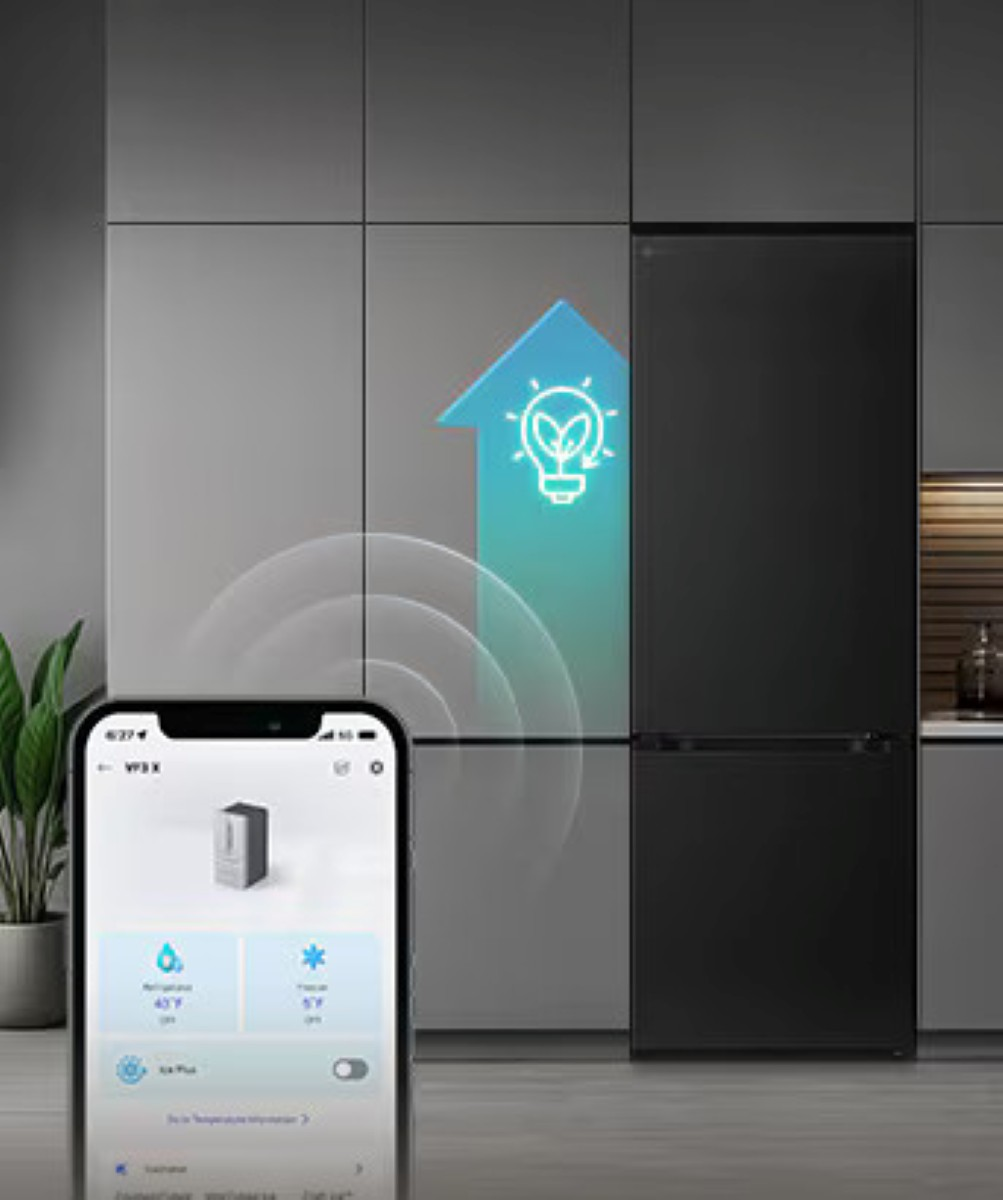 Czarna lodówka ze smartfonem wyświetlającym regulację temperatury. Ikona żarówki reprezentuje inteligentne zużycie energii.