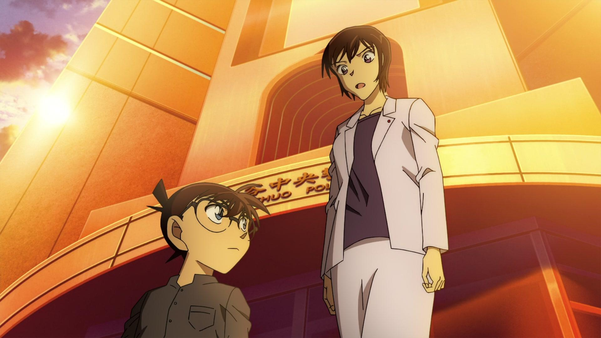 Anime-Szene. Zwei Charaktere stehen vor einem Gebäude. Einer ist ein Junge mit Brille, der andere ein Erwachsener. Der Himmel ist hell.