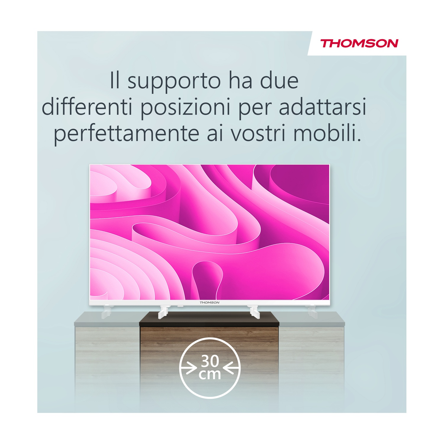 Un televisore Thomson bianco è su un mobile. Il testo recita: 'Il supporto ha due differenti posizioni per adattarsi perfettamente ai vostri mobili.'