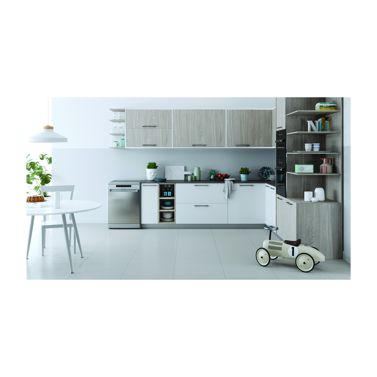 Una moderna cucina con mobili bianchi, lavastoviglie e un'auto giocattolo. Un tavolo rotondo e sedie in primo piano.