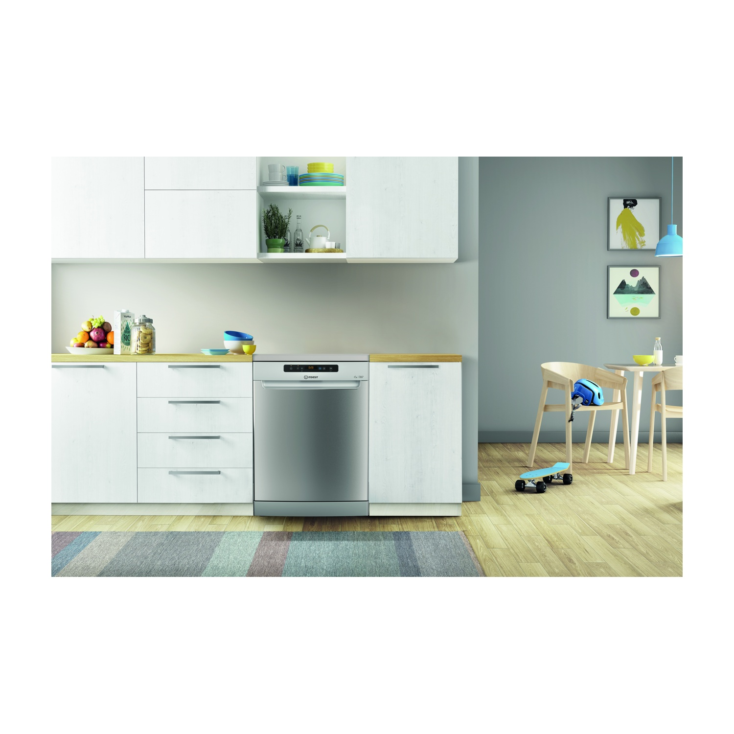 Scena cucina con lavastoviglie. Armadi, tavolo con sedie, skateboard e quadri sulla parete. Frutta sul bancone.