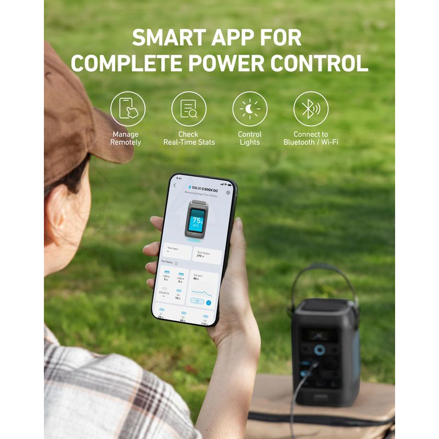 A person holding a phone showing app interface to control a power device. A black power device is in the background.