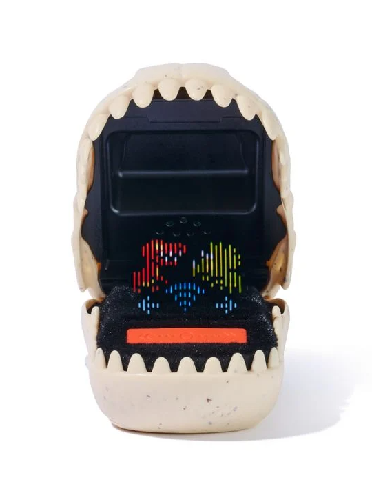 Ein Dinosaurier-Spielzeug mit offenem Maul, das einen Bildschirm mit pixeligen Figuren zeigt. Das Spielzeug ist beige, der Bildschirm ist schwarz.