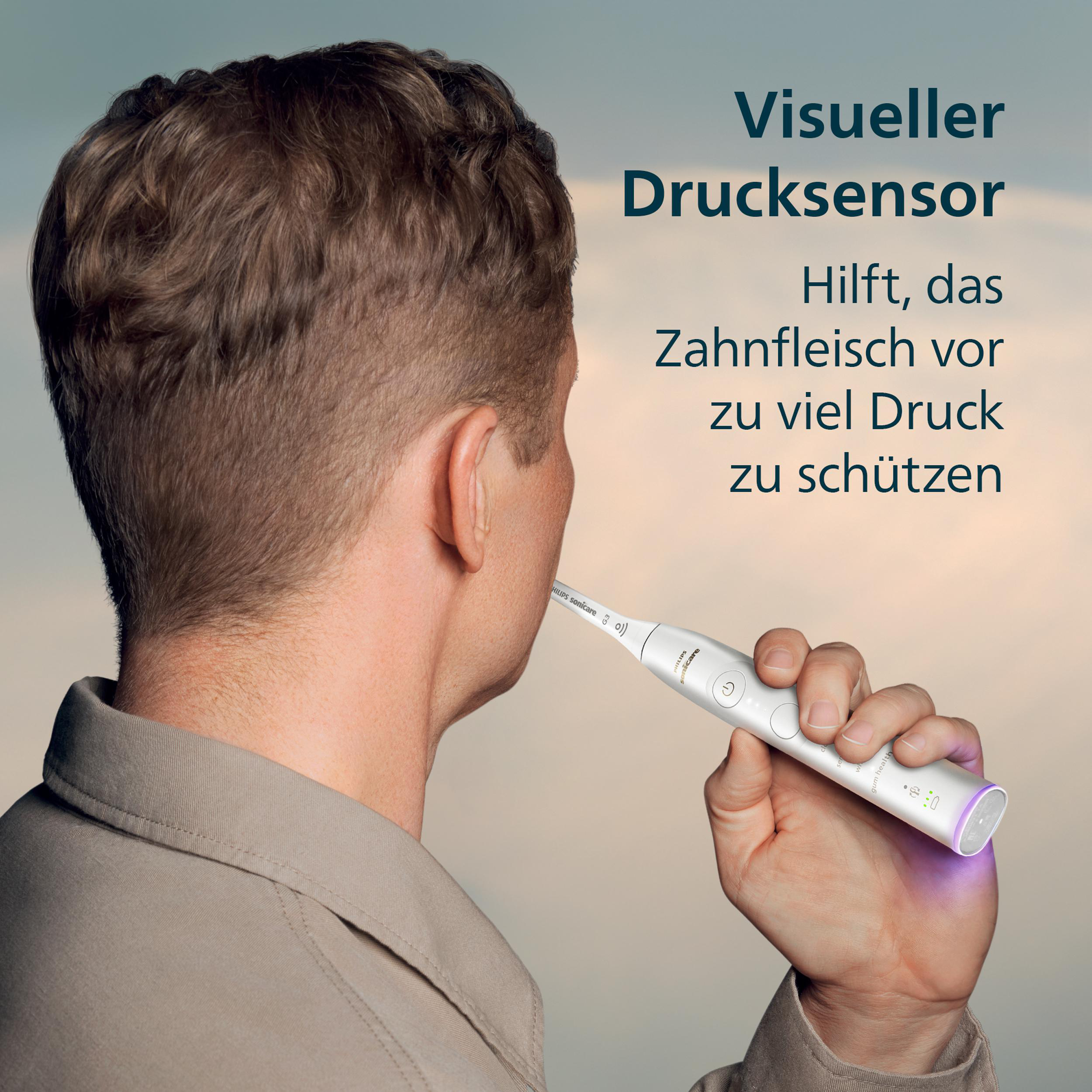 Ein Mann hält eine weiße elektrische Zahnbürste. Text: 'Visueller Drucksensor' und 'Schützt das Zahnfleisch vor zu viel Druck'.