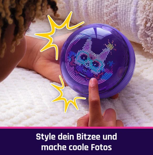 Eine Hand berührt eine lila, leuchtende Kugel. Die Kugel zeigt bunte Muster. Haare sind links sichtbar. Text: Style dein Bitzee und mache coole Fotos.