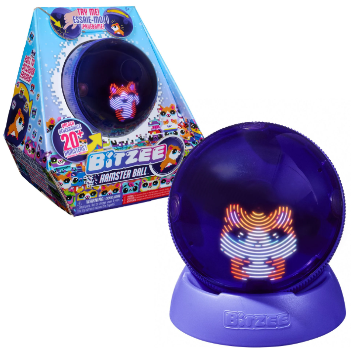 Ein Bitzee Hamster Ball-Spielzeug wird gezeigt. Es ist eine klare lila Kugel mit einem aufleuchtenden Hamster darin, neben der Verpackung.