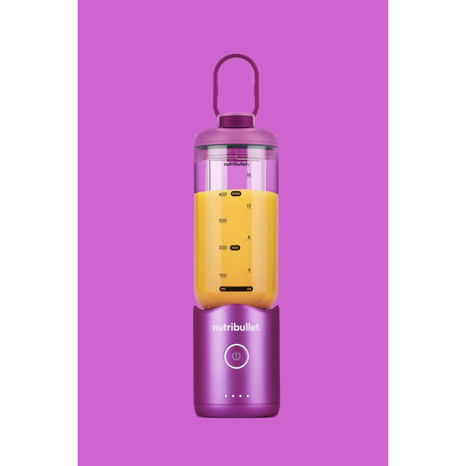 Un frullatore Nutribullet viola con succo all'interno, su sfondo viola. Ha una maniglia e misura in ml e oz.