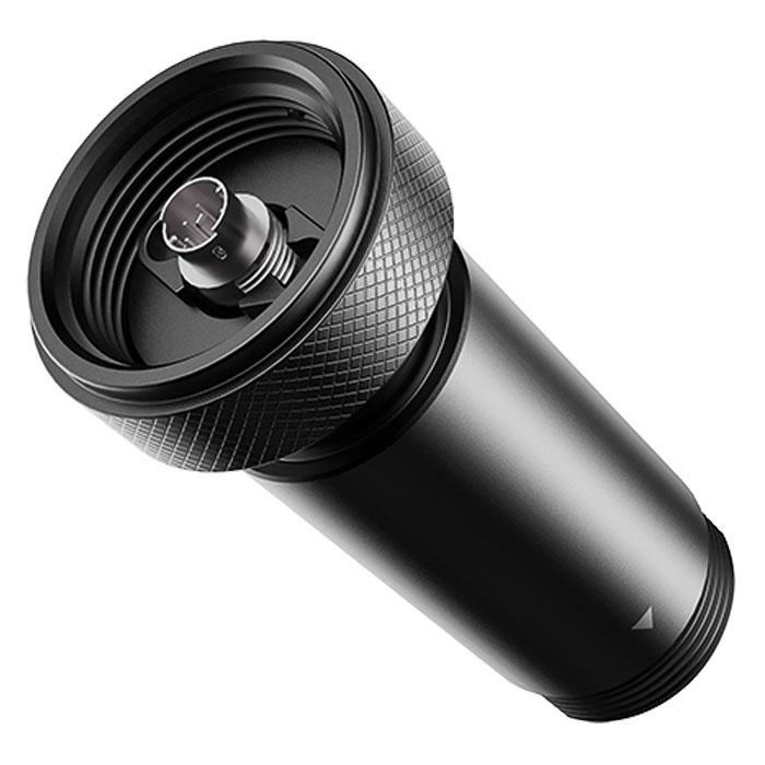 Ein schwarzes zylindrisches Gerät mit strukturierter Oberseite und glattem Körper. Es hat eine metallische Innenkomponente und einen Richtungspfeil.