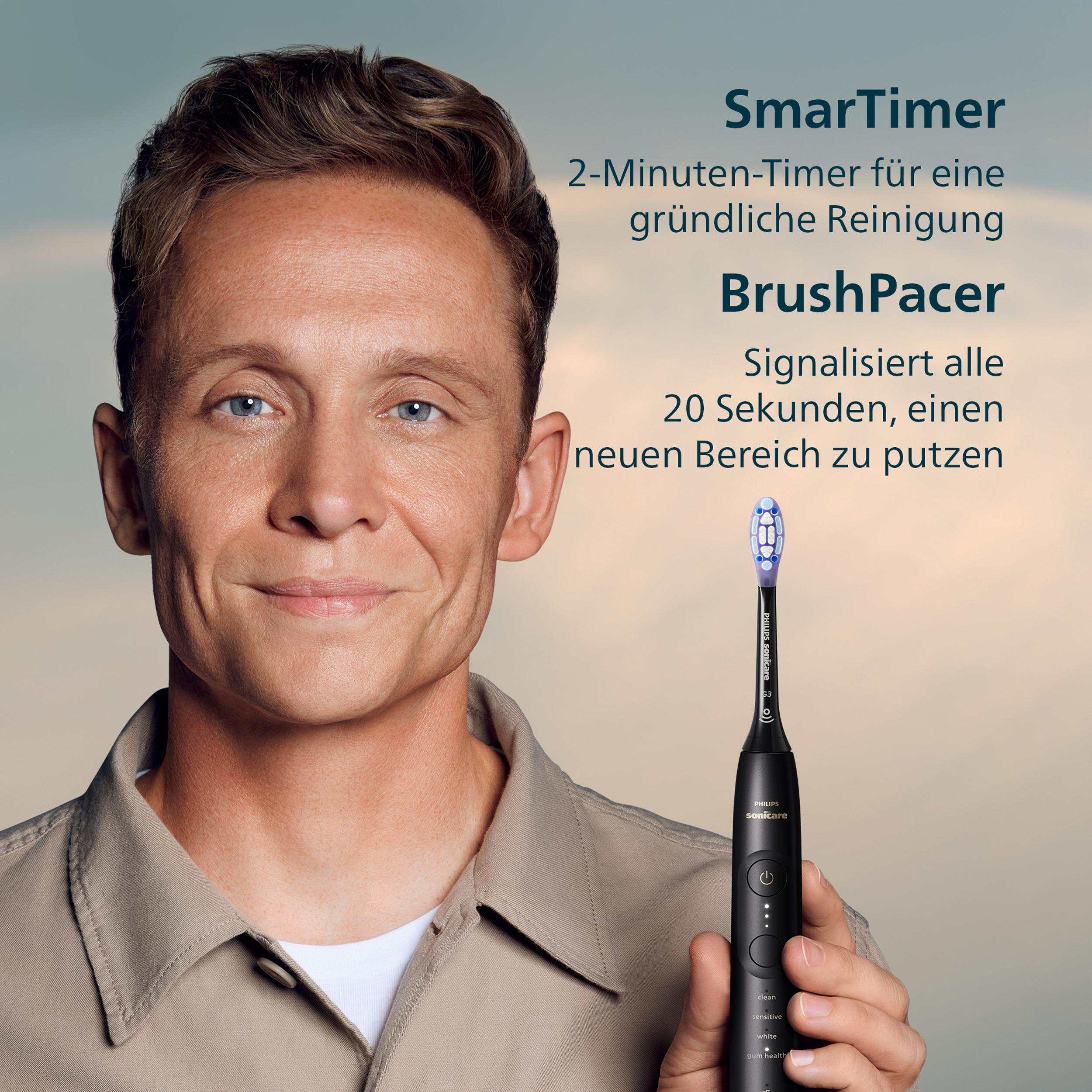 Ein Mann hält eine schwarze Philips Sonicare Zahnbürste. Text-Overlays sagen 'SmarTimer' und 'BrushPacer'.