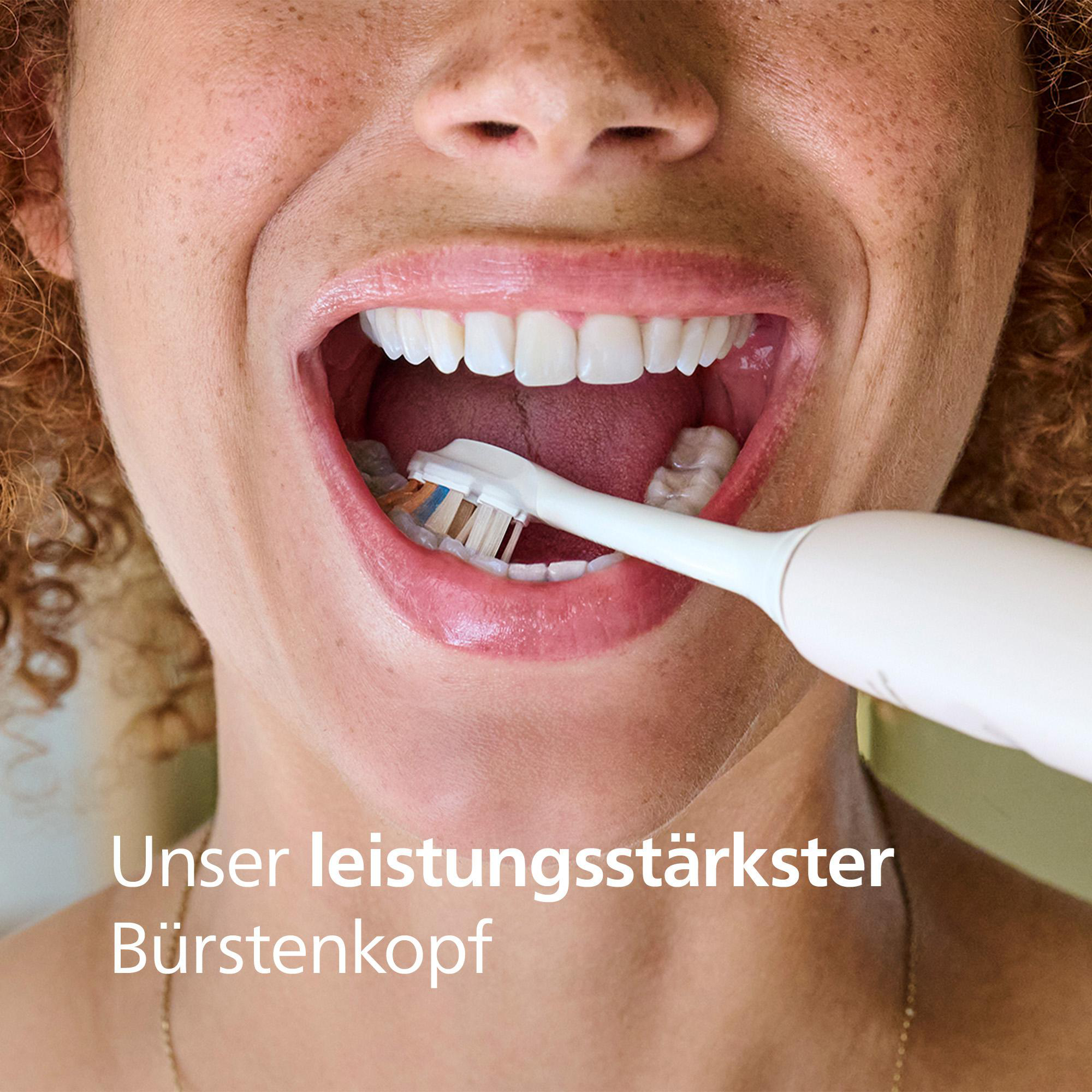 Nahaufnahme einer Person, die sich mit einer elektrischen Zahnbürste die Zähne putzt. Die Person lächelt und zeigt weiße Zähne.