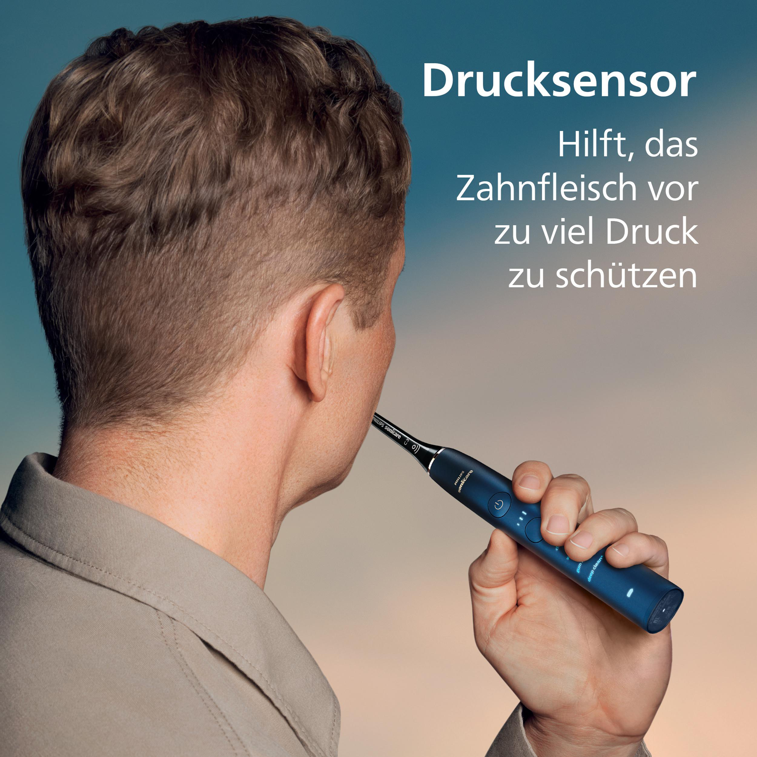 Ein Mann hält eine blaue Zahnbürste und demonstriert ihre Verwendung. Text sagt 'Drucksensor' und wie er das Zahnfleisch schützt.