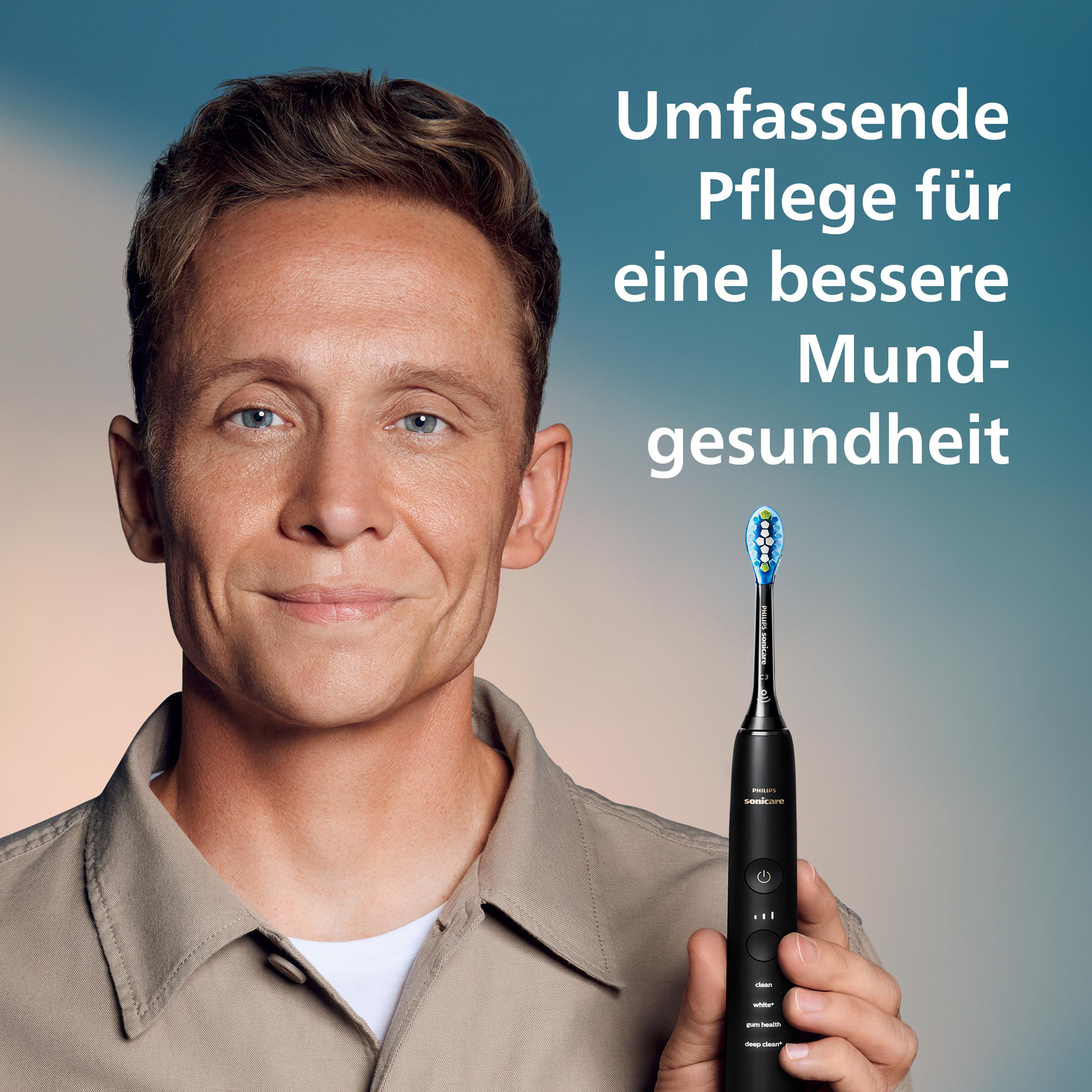 Ein Mann hält eine schwarze Philips Sonicare Zahnbürste. Text auf Deutsch bewirbt Mundgesundheit. Blauer Hintergrund.