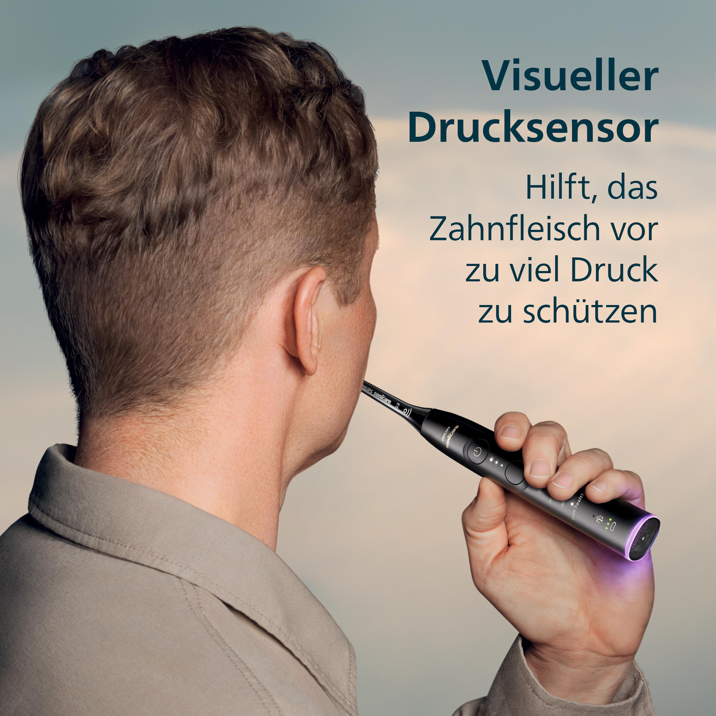 Ein Mann hält eine schwarze Philips Sonicare Zahnbürste. Text auf Deutsch schützt das Zahnfleisch vor Druck.