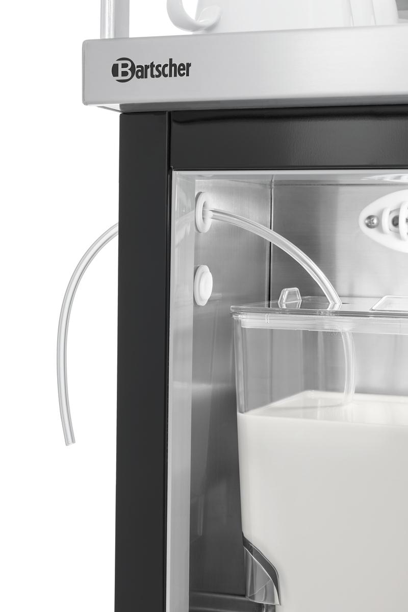 Nahaufnahme einer Bartscher-Maschine mit Milchbehälter. Ein klarer Schlauch krümmt sich in den Behälter. Die Maschine ist schwarz und silber.