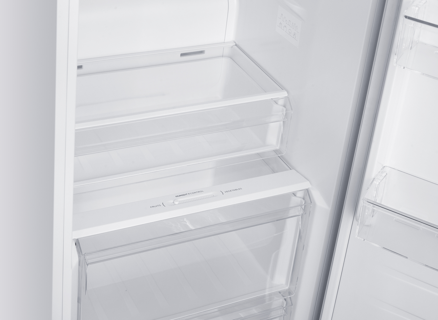 Interior de un refrigerador blanco. Se ven cajones y estantes. Control de humedad para frutas y verduras.