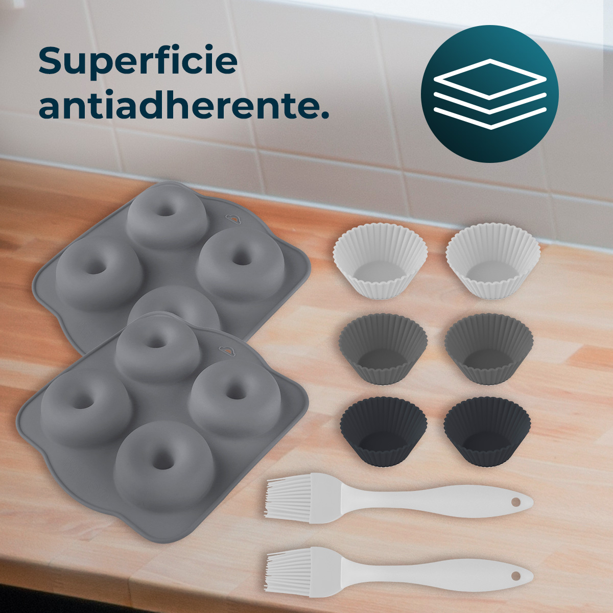 Imagen muestra suministros para hornear: moldes para donas grises, moldes para magdalenas blancos y grises, dos pinceles blancos. Texto: Superficie antiadherente.