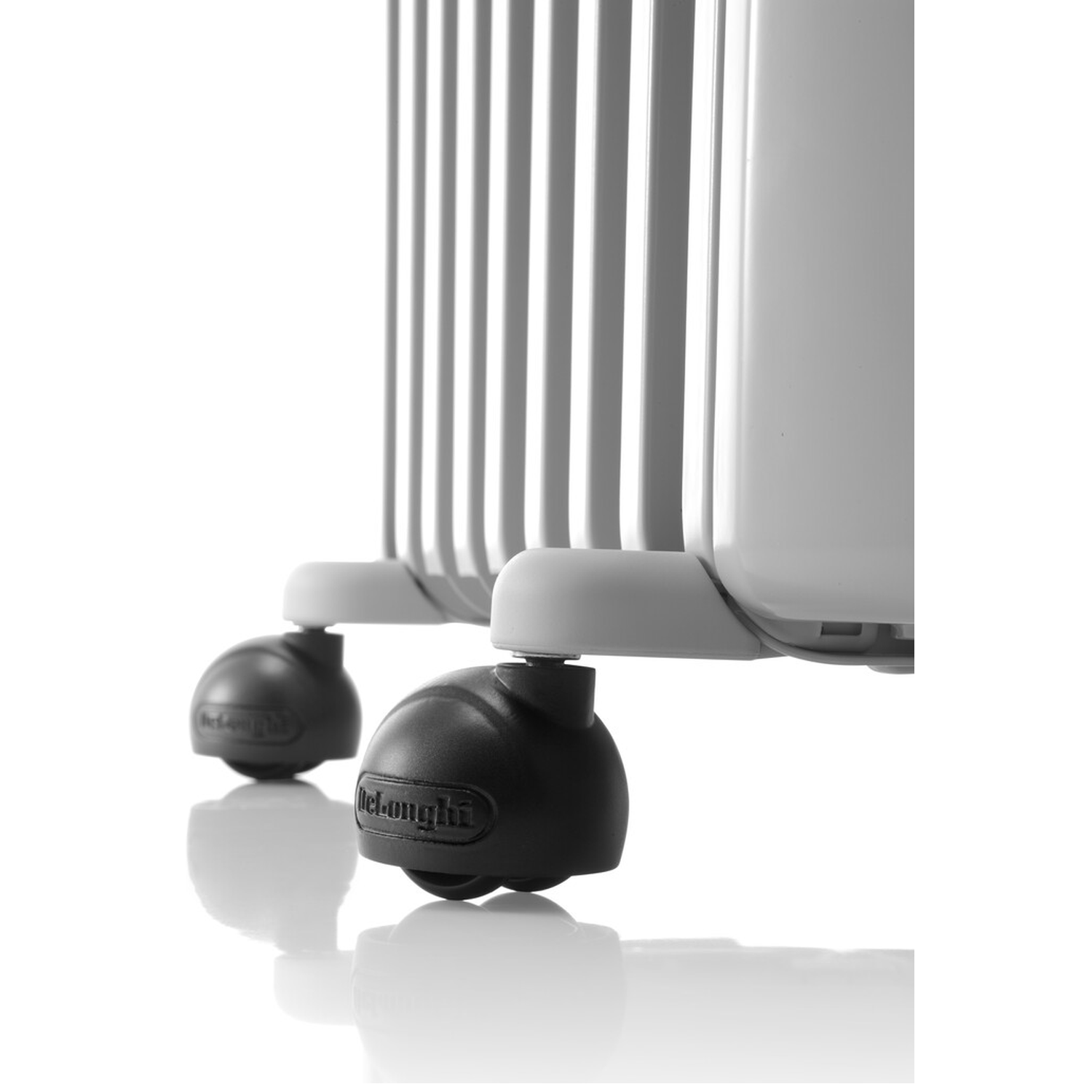 Close-up of a white oil-filled radiator. The radiator has wheels and the Delonghi logo is visible on one of them.