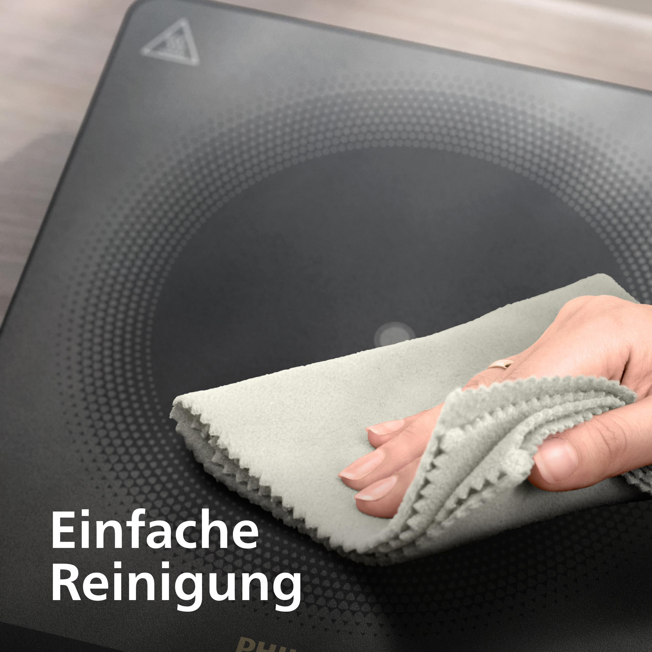 Eine Hand reinigt eine schwarze Herdplatte mit einem grauen Tuch. Der Text 'Einfache Reinigung' steht unten links.