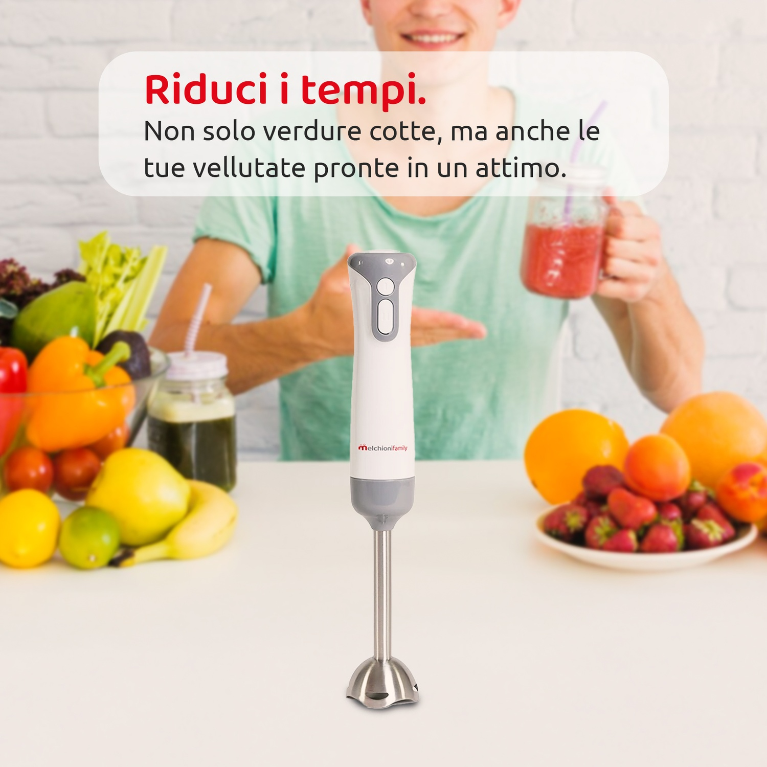 Un uomo tiene in mano un frullato. Davanti, un frullatore a immersione bianco e grigio. Frutta e verdura sul tavolo. Testo: 'Riduci i tempi'.