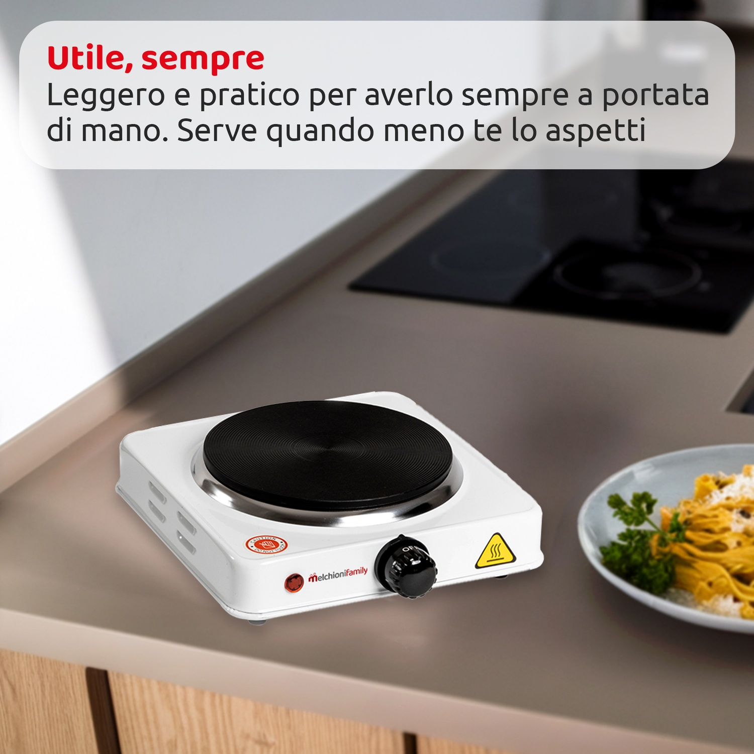 Un fornello portatile bianco con un elemento riscaldante nero è su un piano cucina. Un piatto di pasta è accanto.
