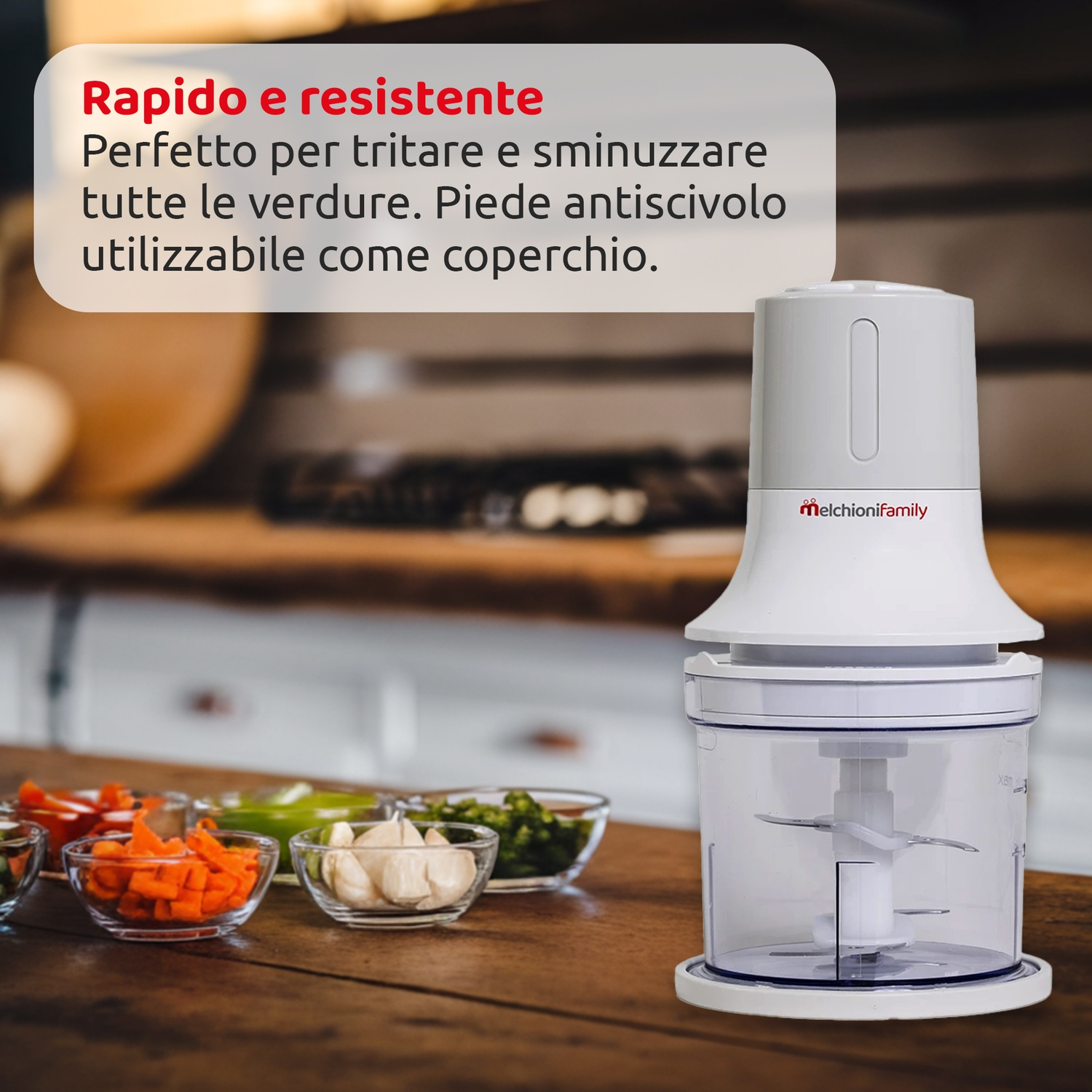 Un robot da cucina bianco con un contenitore trasparente e verdure in ciotole di vetro su una superficie di legno.