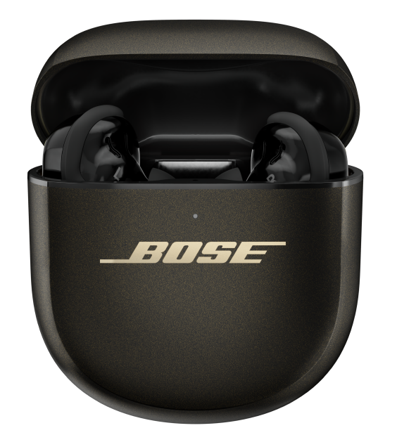 Otwarty futerał ładujący Bose ze słuchawkami w środku. Ciemne etui ze złotym logo Bose. Słuchawki czarne.
