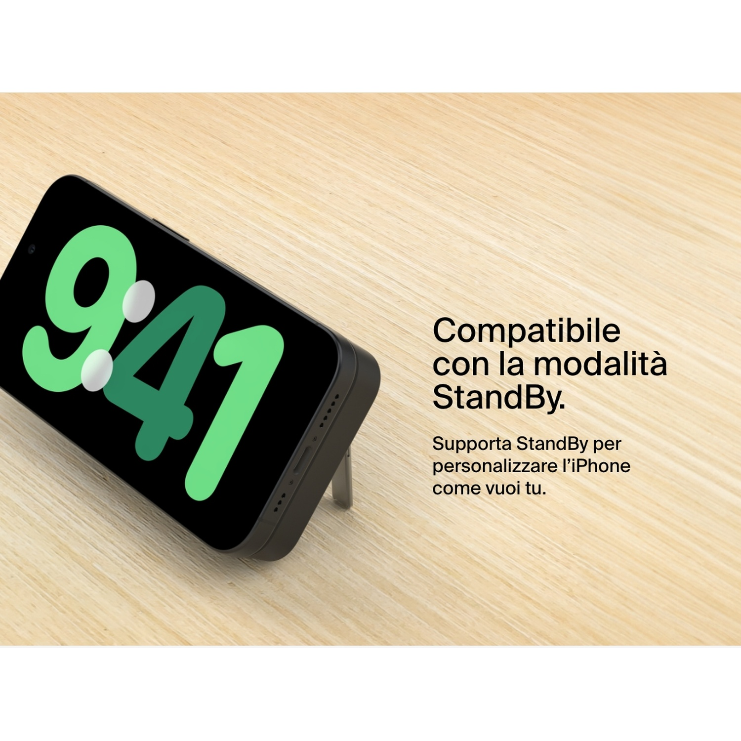Un iPhone nero mostra le 9:41 sullo schermo, appoggiato su un supporto su una superficie di legno, con testo italiano.