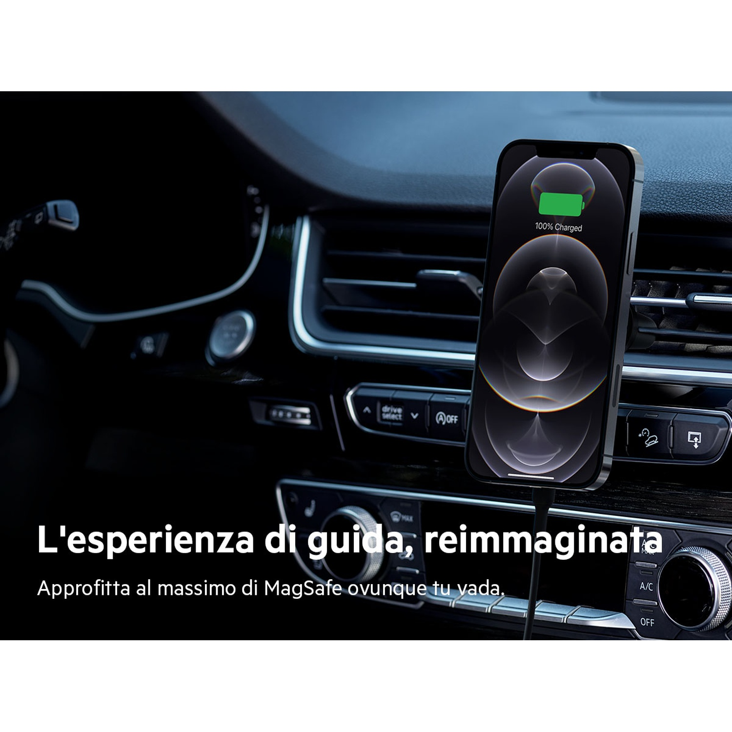 Un iPhone in carica in un'auto. Il telefono mostra 100% caricato. L'immagine è scattata dall'interno dell'auto, mostrando il cruscotto.