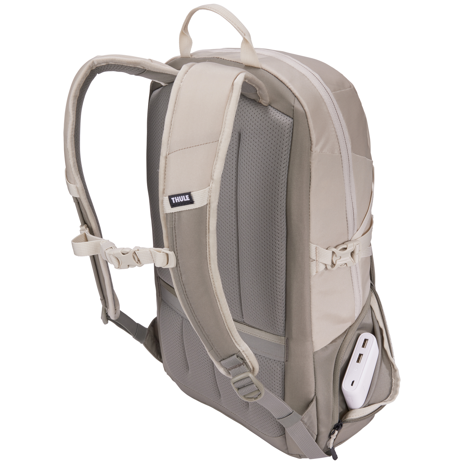 Beige backpack with gray accents, visible straps and a white power bank in the side pocket. Thule brand logo visible.