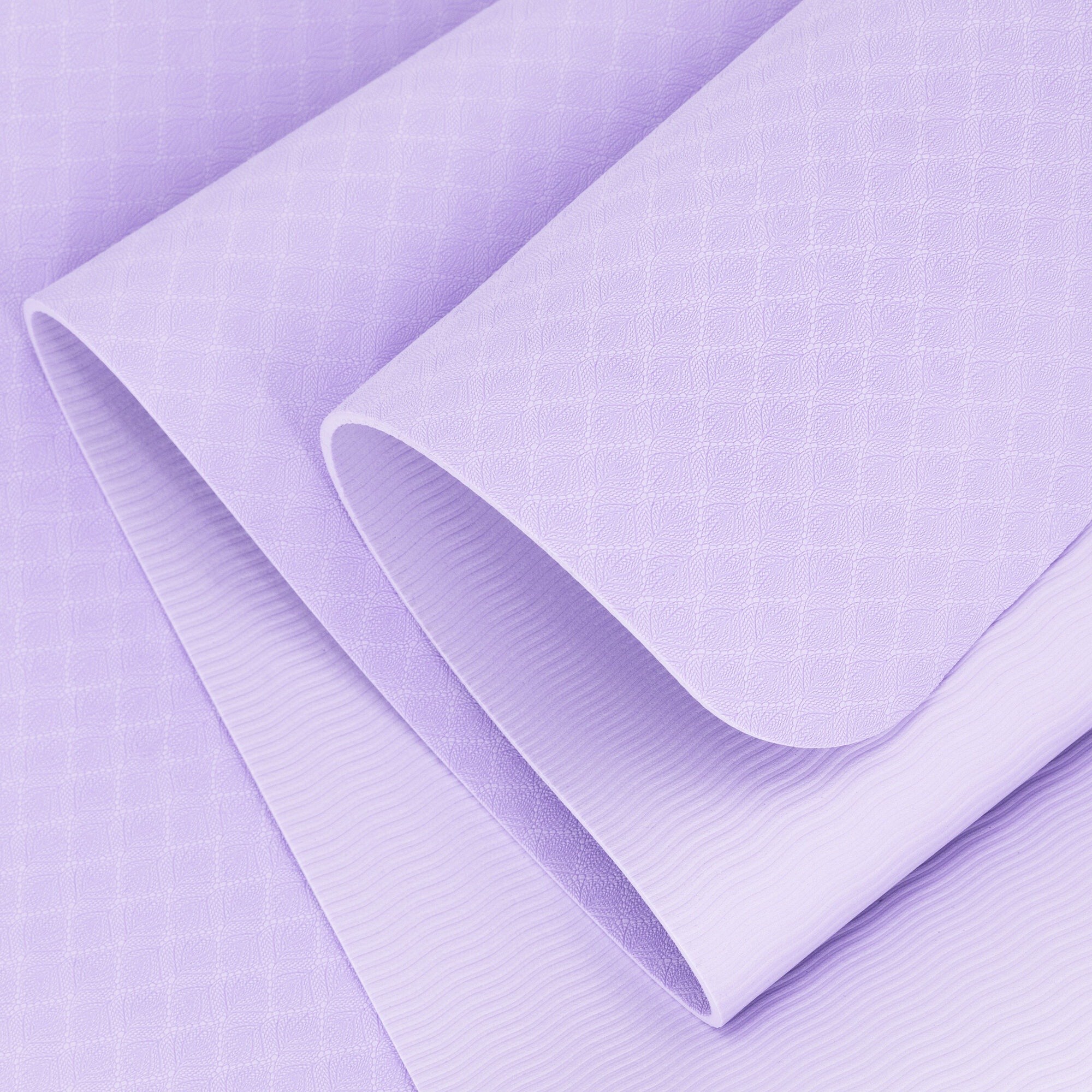 Zbliżenie liliowej tkaniny złożonej na sobie. Górna warstwa ma wzór rombu, dolna ma faliste linie.