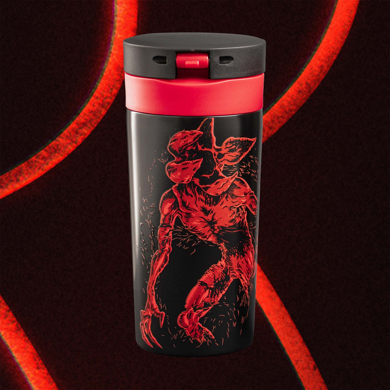 Tazza da viaggio nera con illustrazione rossa di Demogorgon. Dettagli rossi sul coperchio e anello rosso. Linee rosse sullo sfondo.