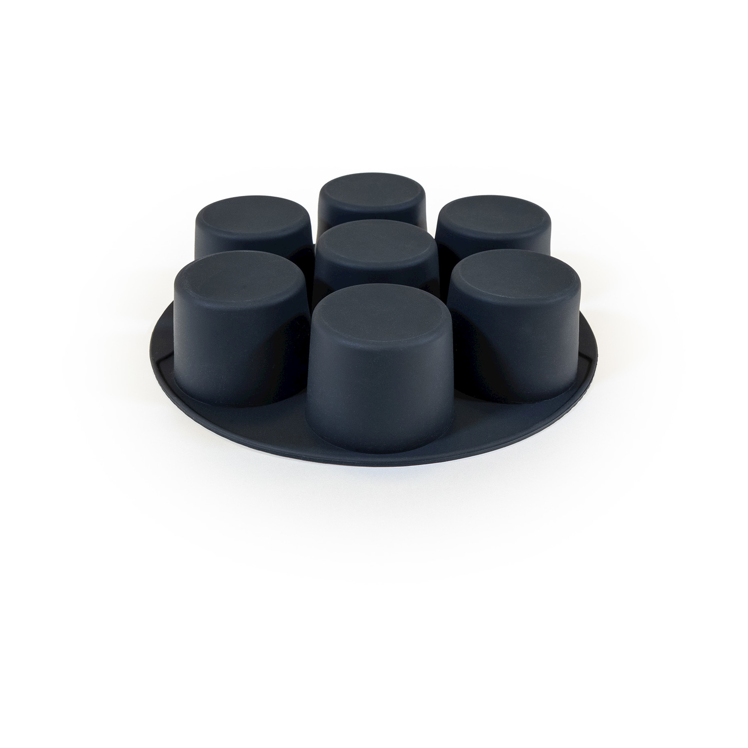 Uno stampo in silicone nero con sette tazze cilindriche disposte a cerchio su sfondo bianco.