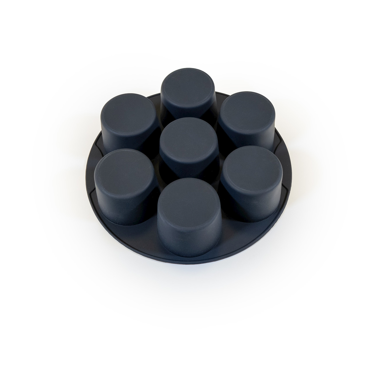 Una teglia per muffin in silicone blu scuro con sette stampi circolari su sfondo bianco. Gli stampi sono disposti a cerchio.