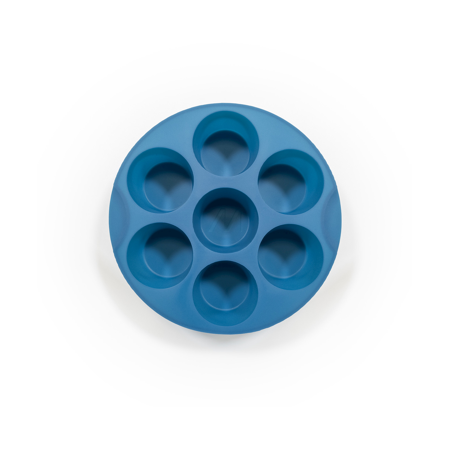 Uno stampo circolare in silicone blu con sette cavità rotonde, visto dall'alto. Si trova su uno sfondo bianco.