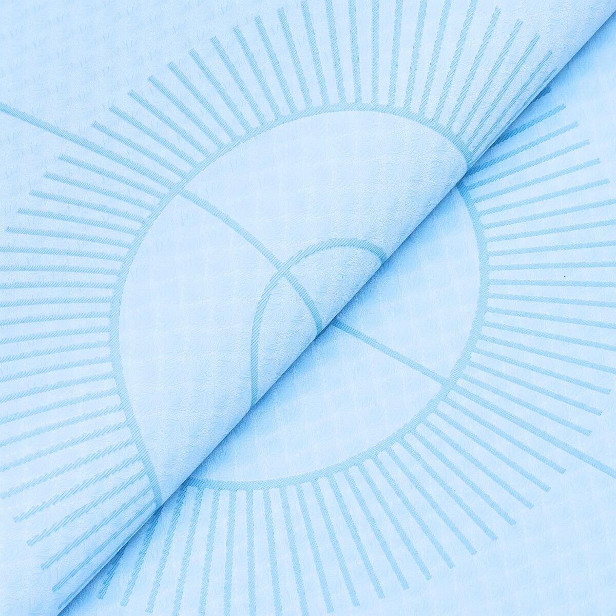 Jasnoniebieska mata do jogi z wzorem słońca, częściowo zwinięta. Linie i okręgi tworzą wzór.