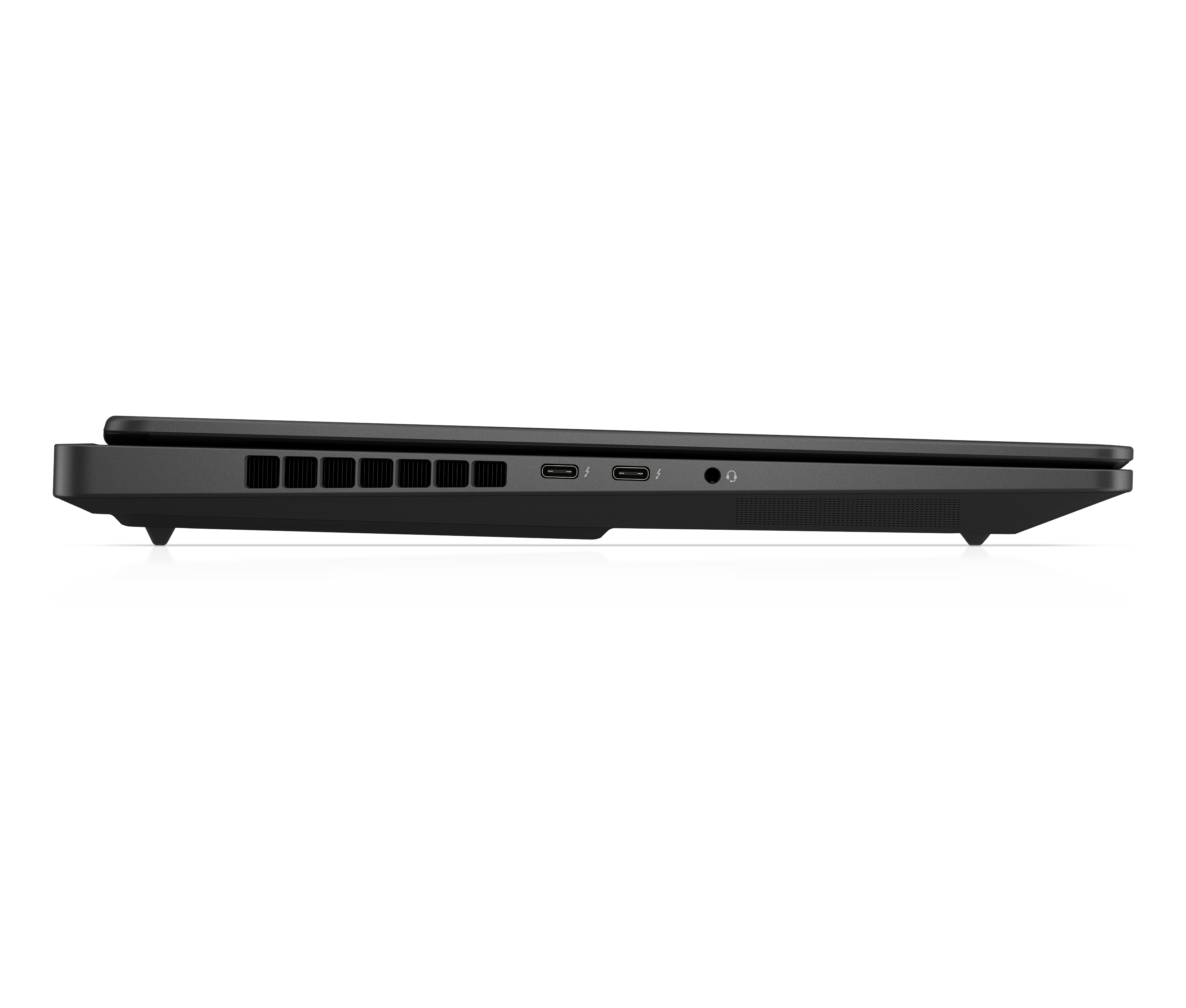 Side view of a black laptop. It is elevated on small feet over a white surface. The laptop is closed.