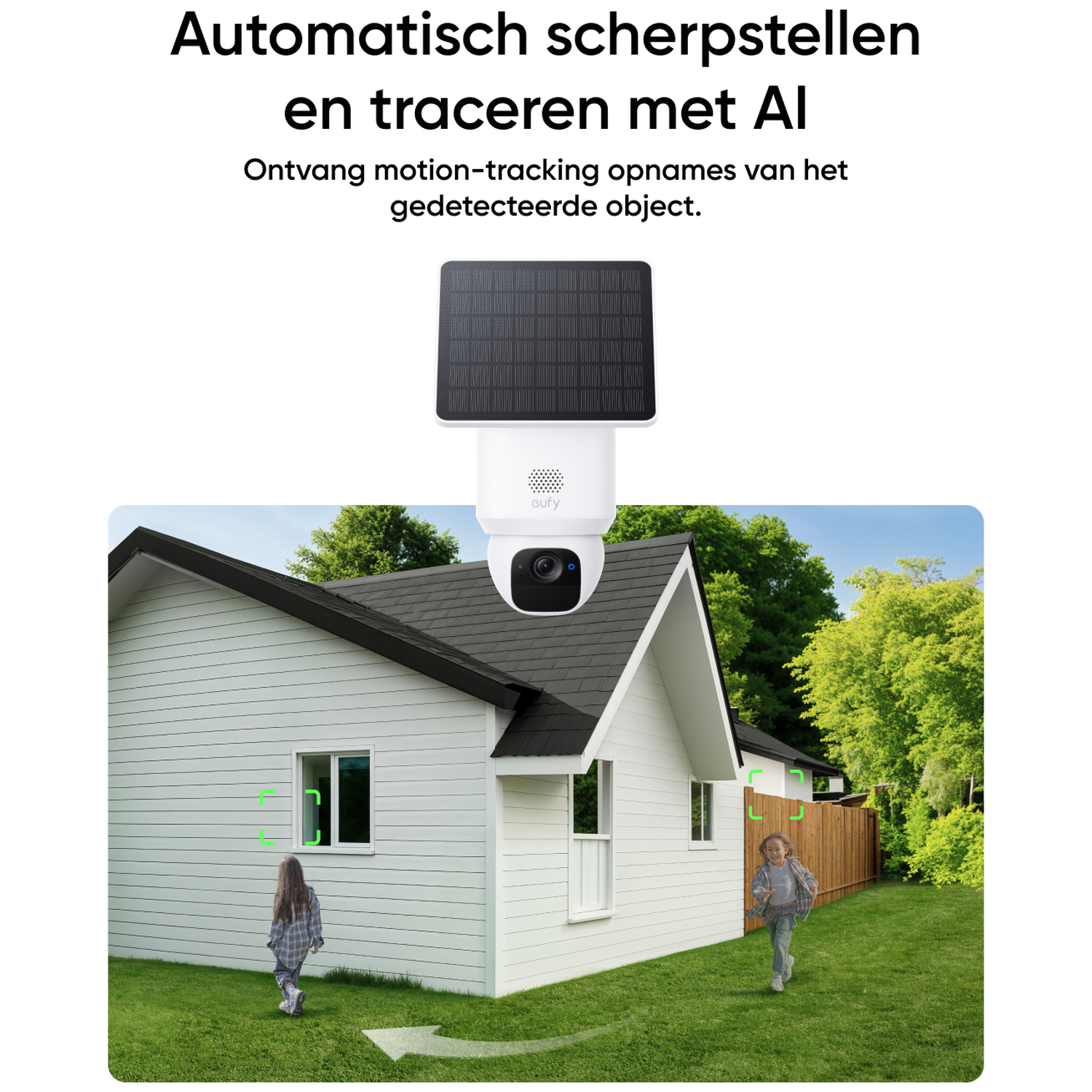 A security camera with a solar panel on top is pointed at a house. Two children are running on the grass. Green trees are in the background.