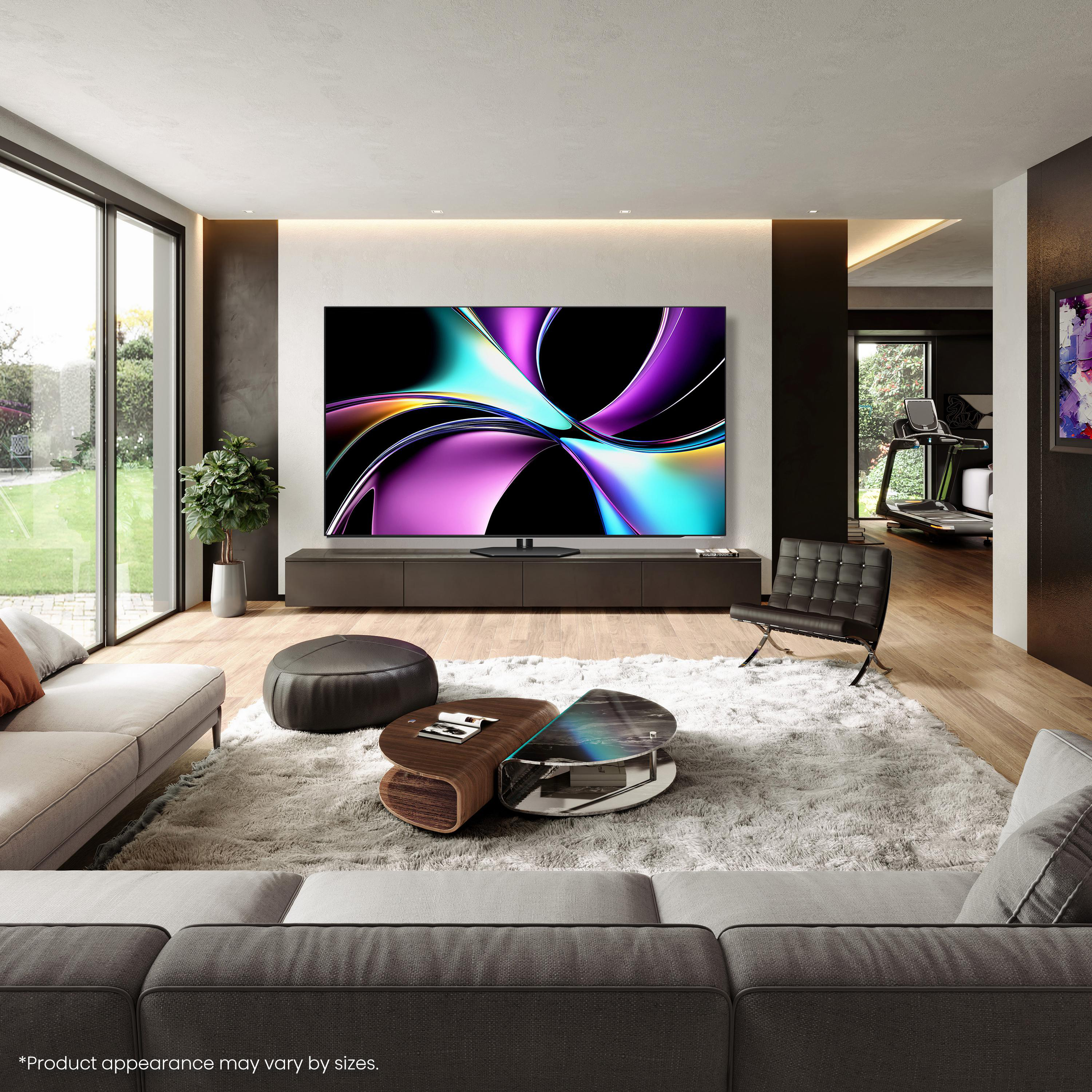 Wohnzimmer mit großem Fernseher, Sofa, Couchtisch und Laufband im Hintergrund. Modernes Design, neutrale Farben.