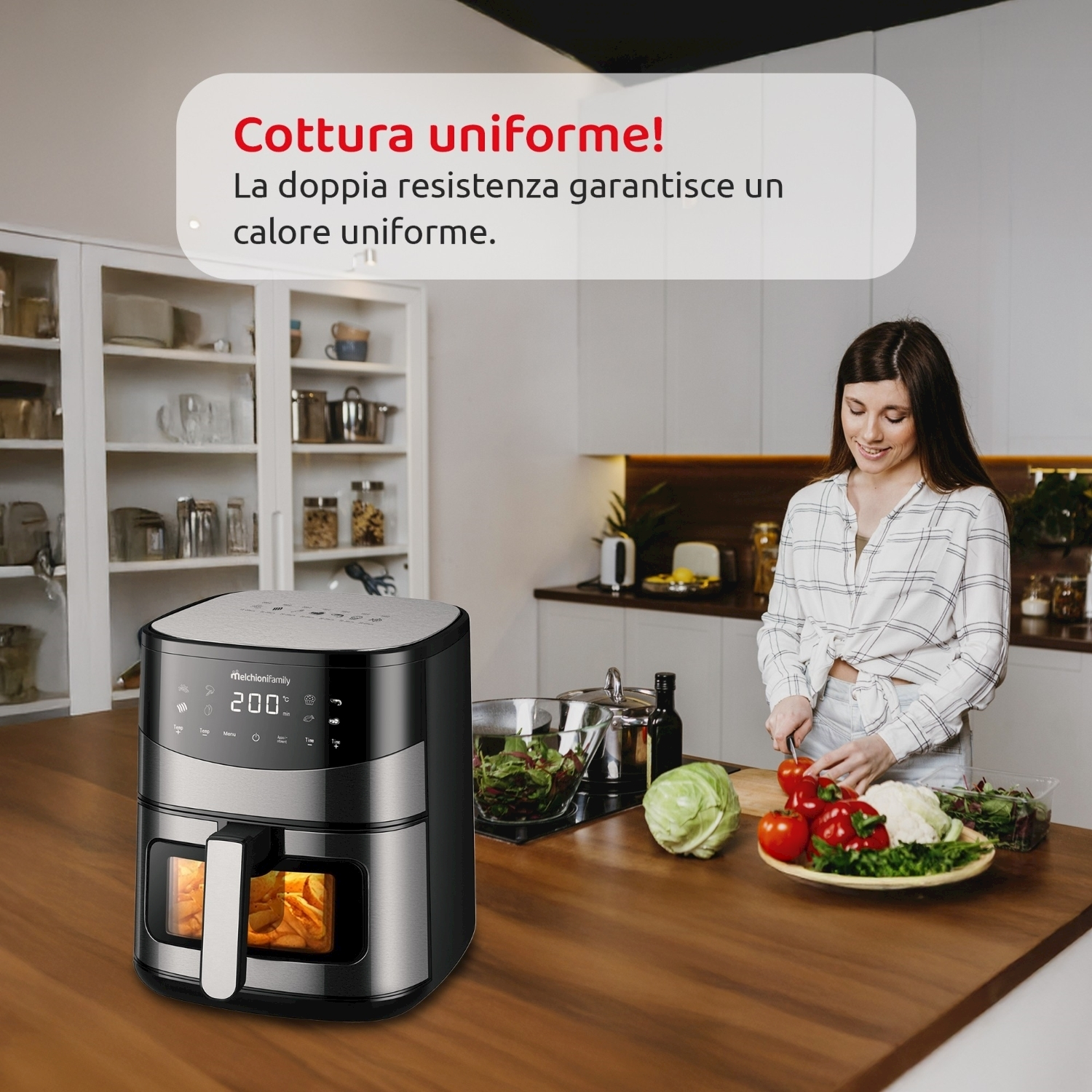 Una donna in cucina taglia verdure vicino a una friggitrice ad aria. Una friggitrice ad aria è sul tavolo.