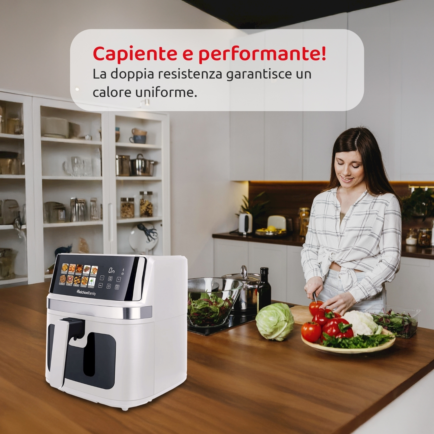 Una donna taglia verdure in una cucina. Una friggitrice ad aria è sul bancone. Varie verdure sono su un piatto. Gli armadi sono sullo sfondo.